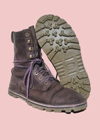 Brown leather boot with purple laces on a wooden stool against a light background