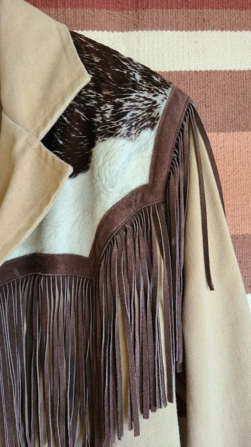 Beige coat with brown leather accents and fringes on a striped background