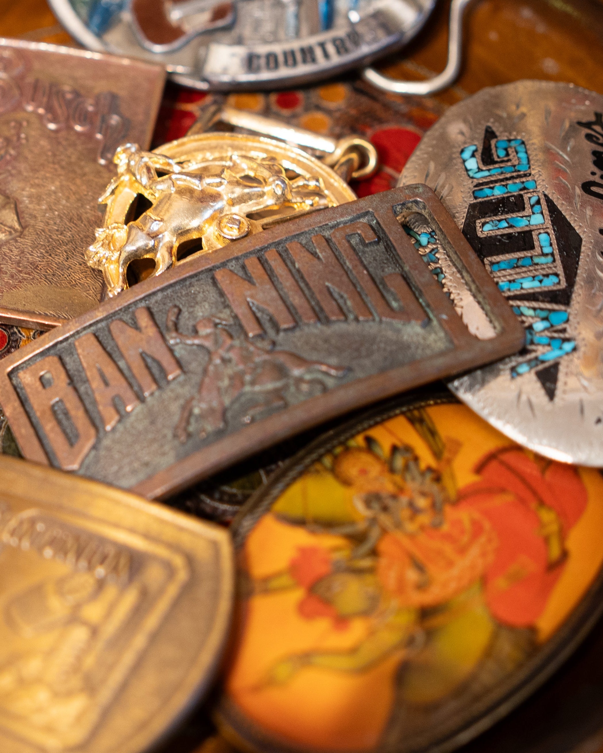 Collection of various vintage belt buckles on a wooden surface